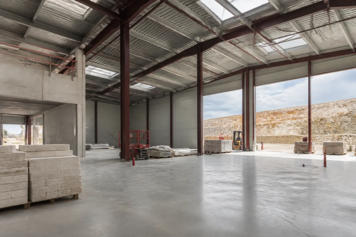 Intérieur d&rsquo;un entrepôt neuf avec dallage lisse et éclairage zénithal