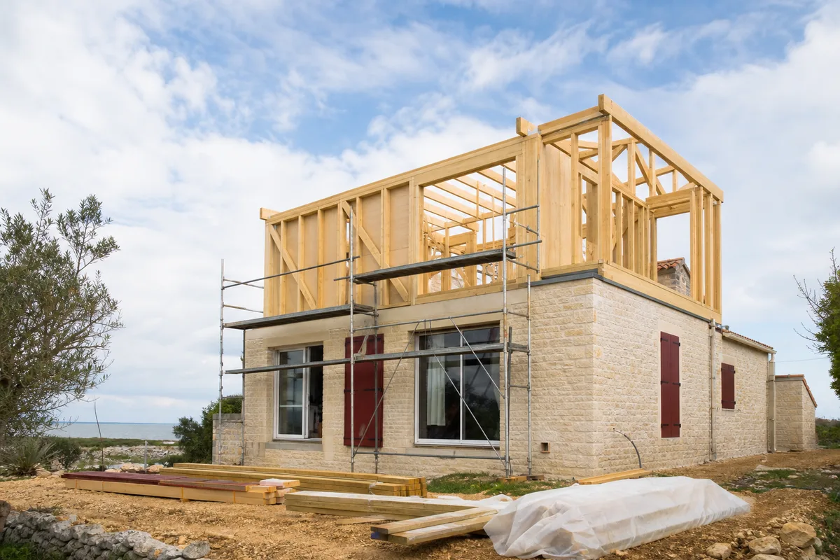 Chantier de surélévation avec ossature bois posée sur une maison existante