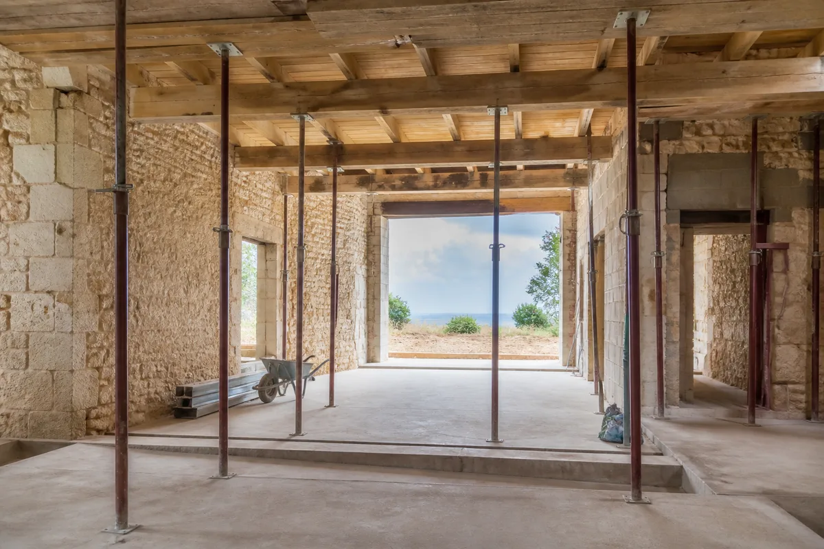 Intérieur de maison en rénovation avec murs mis à nu et étais